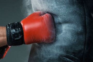 Boxer's fist punching heavy bag Boxer's fist punching heavy bag
