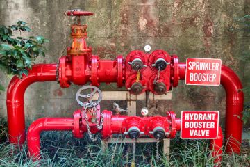 Bright red pipes, taps and valves as part of the fire protection system for a building in Sydney, New South Wales, Australia