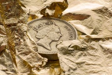 British pound coin on gold leaf
