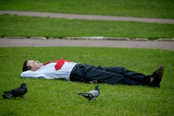 Sleeping businessman in a park on his lunch break, illustrating that employers are taking a back seat with regard to funding higher education. Sleeping businessman in a park on his lunch break, illustrating that employers are taking a back seat with regard to funding higher education.