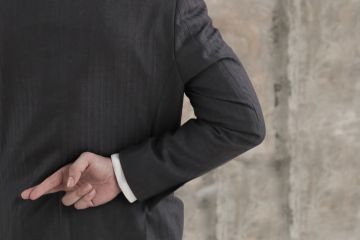 Businessman with his fingers crossed behind his back Businessman with his fingers crossed behind his back