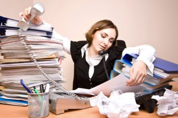 Businesswoman working at cluttered desk Businesswoman working at cluttered desk