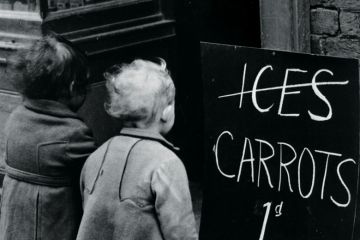 Small children looking at 'Carrots instead of ice lollies' sign Small children looking at 'Carrots instead of ice lollies' sign