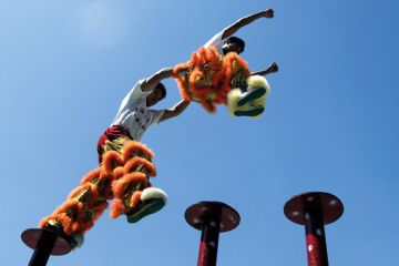 Chinese acrobatic performers jumping between poles Chinese acrobatic performers jumping between poles