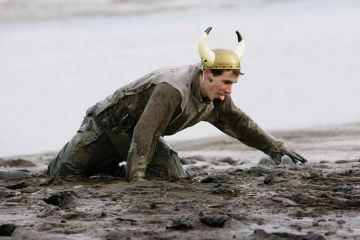Competitor struggles during Maldon Mud Race, Essex Competitor struggles during Maldon Mud Race, Essex