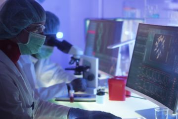 Scientists in protective suits look at Covid images online Scientists in protective suits look at Covid images online