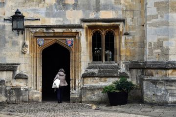 Woman walking through archway at university 