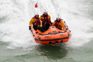 Eastbourne, UK - 17 August, 2013 Royal National Lifeboat Institution (RNLI) in-shore crew on duty at the Eastbourne Air Show on the English Channel, UK on 17 August, 2013.
