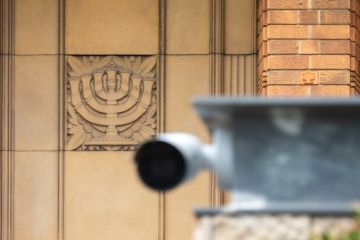 A Menorah engraved in sandstone on the Emanuel Synagogue on Ocean Street, Woollahra in the eastern suburbs of Sydney. In the foreground is a security camer A Menorah engraved in sandstone on the Emanuel Synagogue on Ocean Street, Woollahra in the eastern suburbs of Sydney. In the foreground is a security camer
