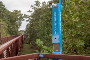 Emergency blue light pole in quiet wooden foot path area