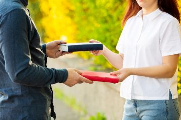 Man and woman exchanging books as a metaphor for concerns over donor influence in higher education philanthropy