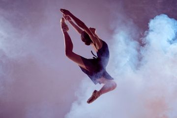 Female ballet dancer jumping through dry ice Female ballet dancer jumping through dry ice