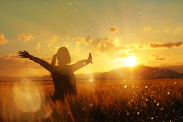 A woman in a wheatfield at sundown