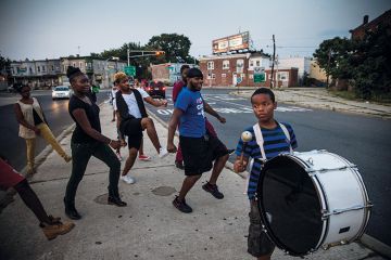 Children dancing in street, following a drummer Children dancing in street, following a drummer
