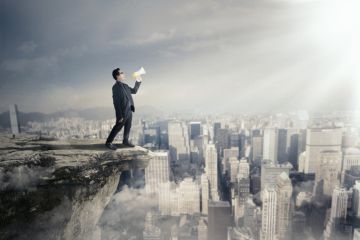 A man with a megaphone on a rooftop, symbolising free speech