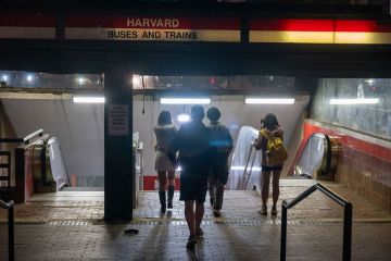 People enter the Harvard transit station on May 27, 2025 in Cambridge, Massachusetts