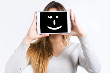 Girl holding a tablet computer with a smiley face on it Girl holding a tablet computer with a smiley face on it