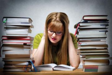 Girl studying surrounded by books Girl studying surrounded by books