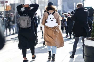 A girl wearing a backpack with a smiley face on it A girl wearing a backpack with a smiley face on it