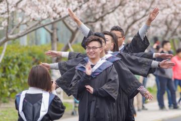 Graduating students taking photos in cherry festival in Tongji University.