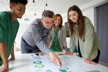 A businessman points at a chart while brainstorming with colleagues, symbolising green business expertise A businessman points at a chart while brainstorming with colleagues, symbolising green business expertise