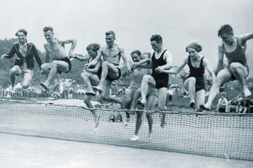 People jumping over tennis net People jumping over tennis net