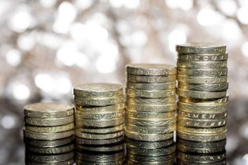 Growing piles of British pound coins