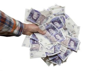 Hand holding £20 notes