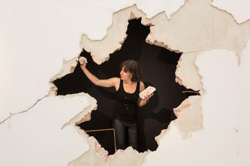 German student presents a big hole in the wall, as students from the Royal College of Art (RCA) Postgraduate Art & Design courses present their final projects. To illustrate the gap in funding for doctoral training.