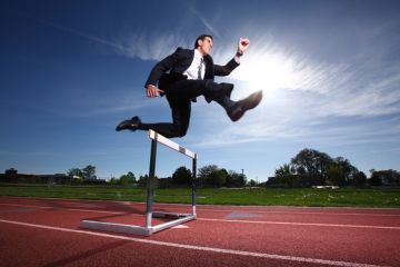 Businessman jumping a hurdle