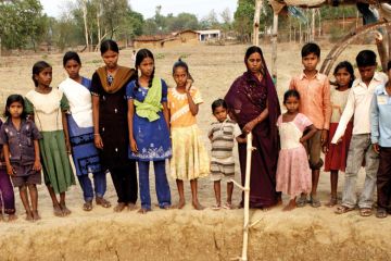 Indian women and children standing beside well Indian women and children standing beside well