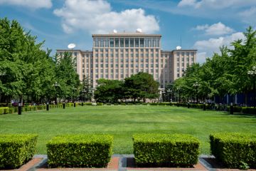 Green gardens and the main Building of the famous Tsinghua University in Beijing, China.