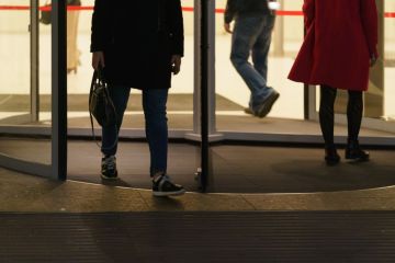 People leaving an office via a revolving door People leaving an office via a revolving door