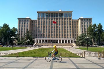 Students biking in front of the main entrance of Tsinghua University in Beijing, China. Students biking in front of the main entrance of Tsinghua University in Beijing, China.