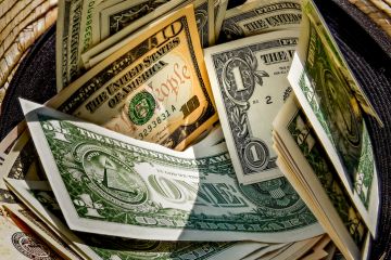 Straw hat with a stack of dollar bills inside