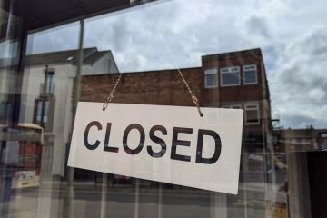 A closed sign hanging in a shop window