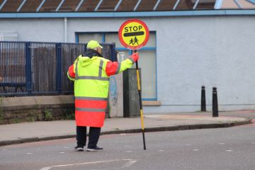 Stop sign Lolly pop man holding "stop" sign