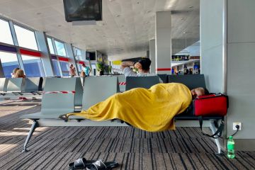 Kiev Ukraine-July 2021: A tired man sleeps on a bench at the airport while waiting for his transit flight. Kiev Ukraine-July 2021: A tired man sleeps on a bench at the airport while waiting for his transit flight.