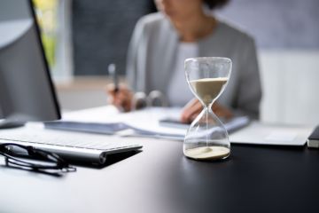 Hourglass on desk running out Hourglass on desk running out