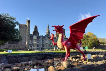 A red dragon in front of the Cardiff Castle and Victorian Gothic revival mansion in Cardiff, Wales. A red dragon in front of the Cardiff Castle and Victorian Gothic revival mansion in Cardiff, Wales.