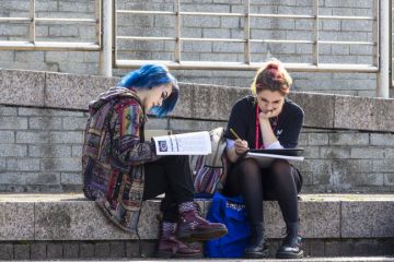 Two young female students studying outdoors.