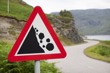 Signing warning that boulders may fall down on the road ahead Signing warning that boulders may fall down on the road ahead