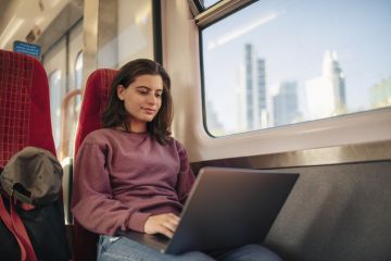 Student commuter on laptop on train