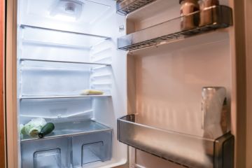 Almost empty fridge with open door 