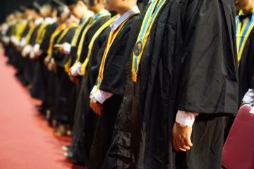 Graduates wearing gowns and sashes at their college commencement ceremonies