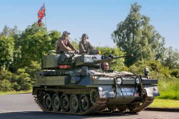 1974 CVR T SCIMITAR military vehicle driving on a British country road. 1974 CVR T SCIMITAR military vehicle driving on a British country road.