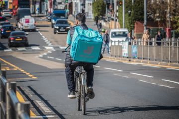 A Deliveroo cycle delivery worker on London street.