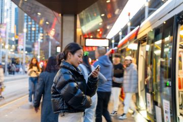 Businesswoman using mobile phone online working at train station
