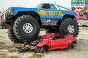 Huge Monster Truck climbs, crushes and completely destroys a demo car. Huge Monster Truck climbs, crushes and completely destroys a demo car.