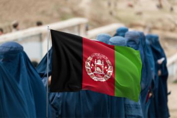 Afghan flag displayed over group of women wearing burqas Afghan flag displayed over group of women wearing burqas